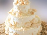 a neutral beach wedding cake decorated with sugar starfish, seashells and sea horses on top for a chic and catchy look