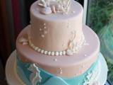 a blush beach wedding cake with blue waves, pearls, bubbles, seashells and corals of sugar looks bright and very catchy