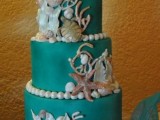 a green beach wedding cake with gorgeous sugar starfish, seashells, pearls, corals and sea horses on top is very chic