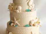 a refined neutral wedding cake with various patterns, orchids, sea glass and seashells, starfish and sea horses of sugar