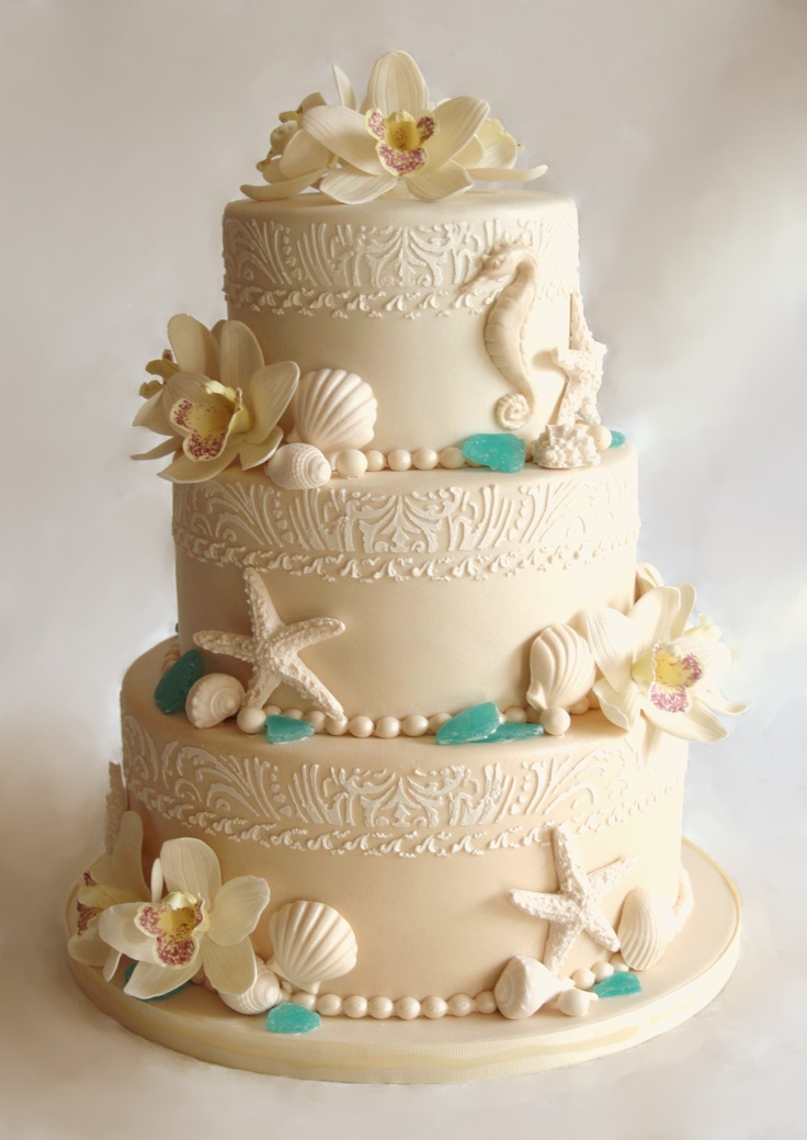 A refined neutral wedding cake with various patterns, orchids, sea glass and seashells, starfish and sea horses of sugar