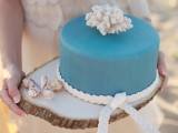 a plain blue wedding cake accented with rope and a coral on top is a lovely idea for a coastal wedding, too