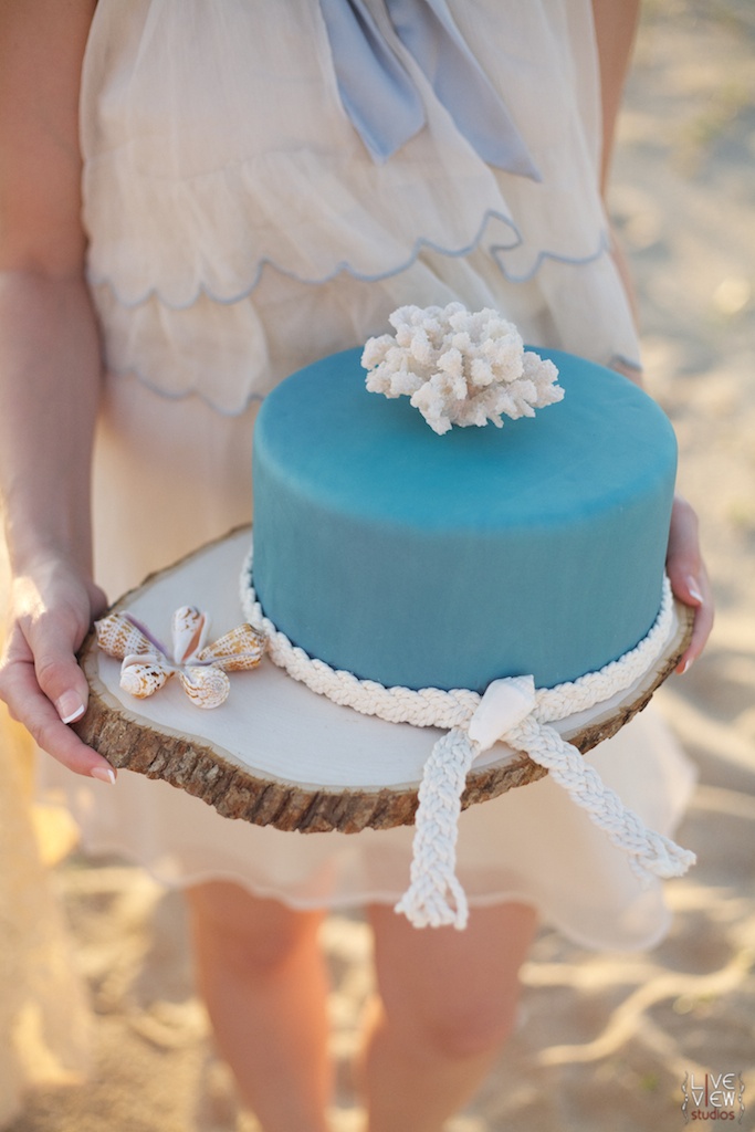 A plain blue wedding cake accented with rope and a coral on top is a lovely idea for a coastal wedding, too