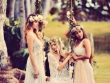boho bridesmaids wearing mismatching neutral dresses and neutral floral crowns on a boho swing interwoven with blooms