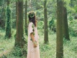a woodland boho bride wearing a neutral A-line lace midi dress, boots and a greenery crown going down the arm