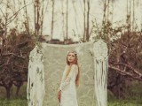 a boho woodland wedding backdrop of lace, with dream catchers, greenery and hanging fringe and macrame is a cool idea