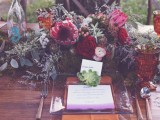 a woodland boho wedding centerpiece of berries, bright blooms, antlers, moss and lots of greenery is a very wild and cool idea