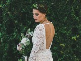 a boho woodland bride in a boho lace sheath wedding dress with an open back, a side slit and a greenery crown is lovely