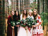 a boho woodland wedding backdrop of colorful yarn put on living trees and boho bridesmaids wearing mismatching burgundy and white dresses