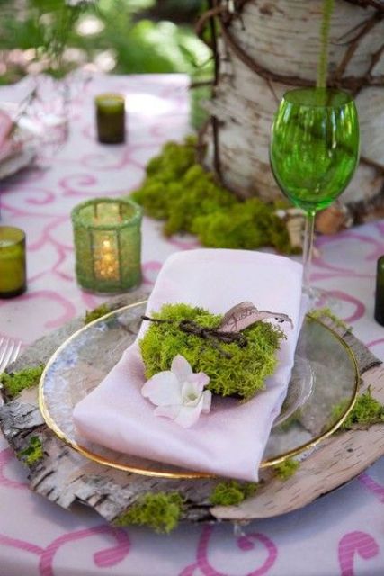a woodland wedding place setting with bark, moss, branches, twigs and green candle holders