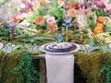 a lush forest wedding table setting with a moss tablecloth, lush blooms and ferns