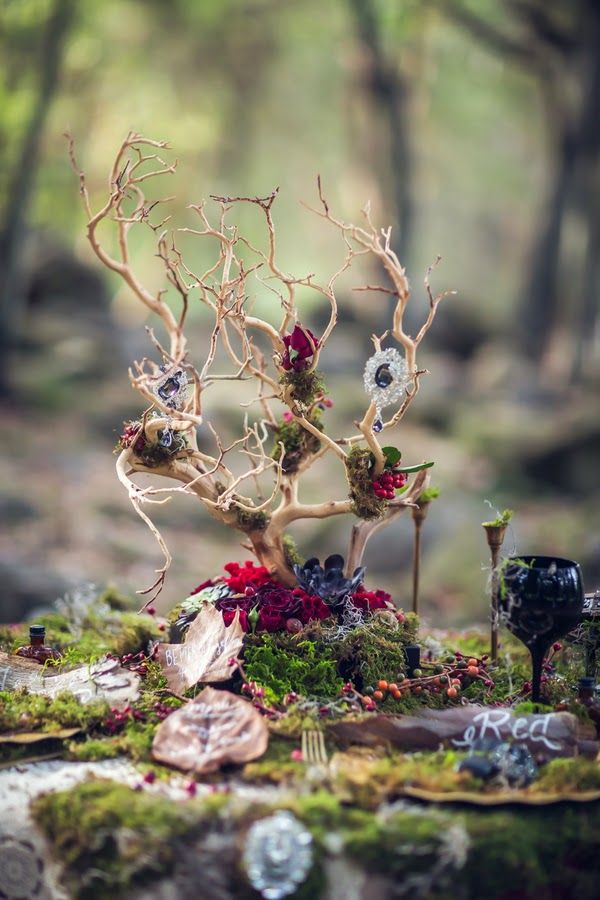A catchy woodland wedding centerpiece of branches, moss, blooms will be ideal for the fall