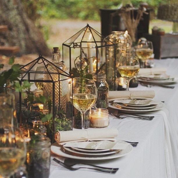 Greenery in terrariums, candles and moss on the table make it woodland like