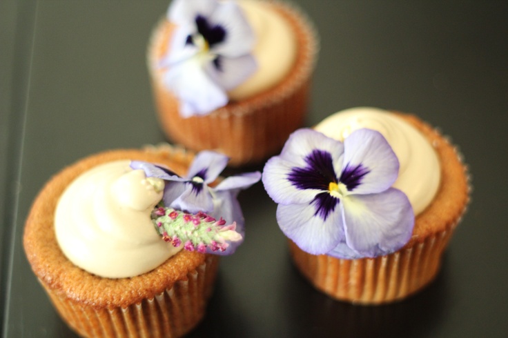 Wedding cupcakes with vanilla frosting, pansy flowers and sage blooms look veyr summery and very bright and taste delicious