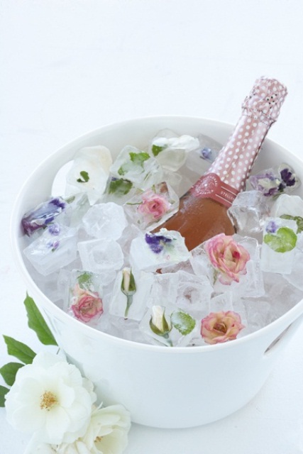 a bottle of prosecco placed into a bowl with floral ice is wonderful and chic and this idea is proper for a summer flower-filled wedding or bridal shower