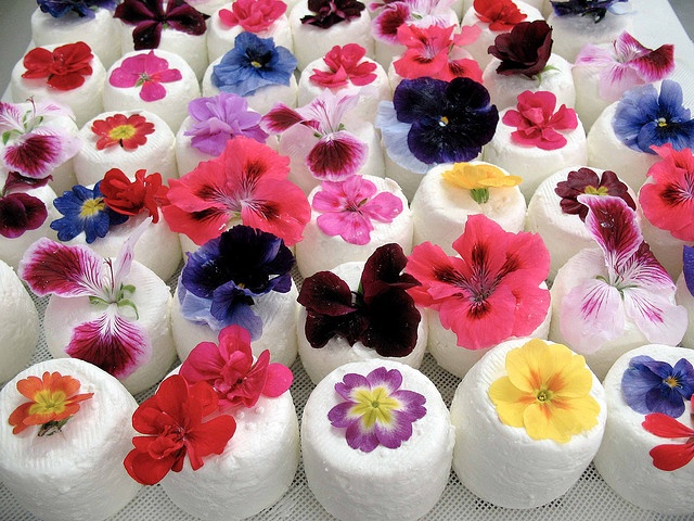 White mini wedding cakes topped with all different edible flowers are a great idea for a spring or summer flower filled wedding