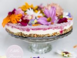 a wedding cheesecake with fruit jam and colorful edible flowers on top is ideal for a boho summer wedding