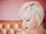 an art deco bridal headpiece of rhinestones and an embellished feather is a lovely and bold accent