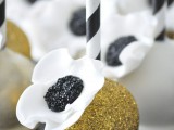 gold glitter cake pops with black and white blooms on top is a fun dessert idea