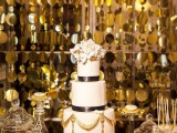 a black and white wedding cake, a black, white and gold wedding dessert table and a gold backdrop