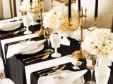 a refined black, white and gold wedding table setting with lush white rose centerpieces
