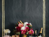 a black and gold backdrop, gold vases and glasses
