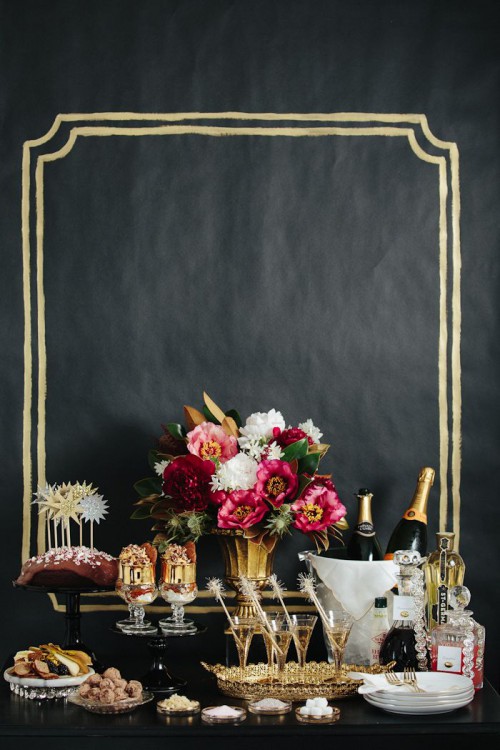 a black and gold backdrop, gold vases and glasses