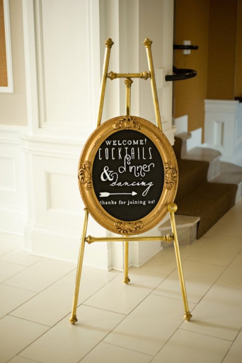 a black chalkboard wedding sign with a gold frame