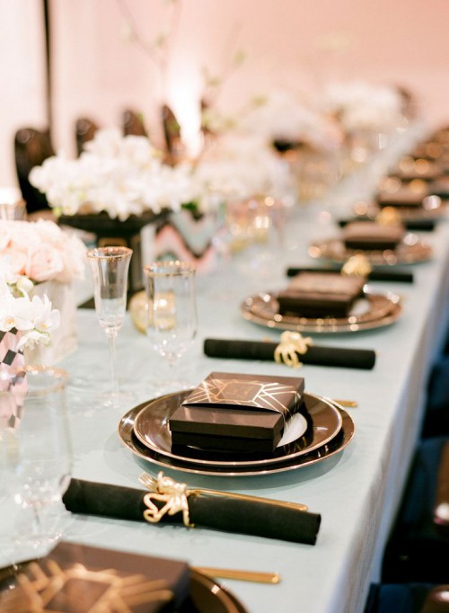black and gold wedding decor, blush bloom centerpieces and a blue tablecloth