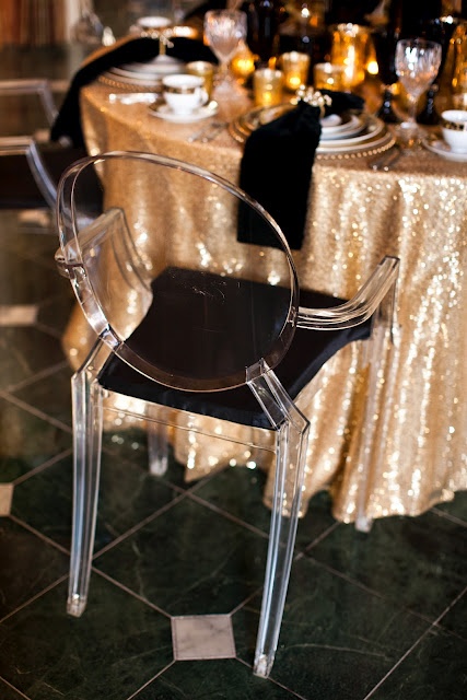 gold sequin tablecloths, black napkins and acrylic and black chairs