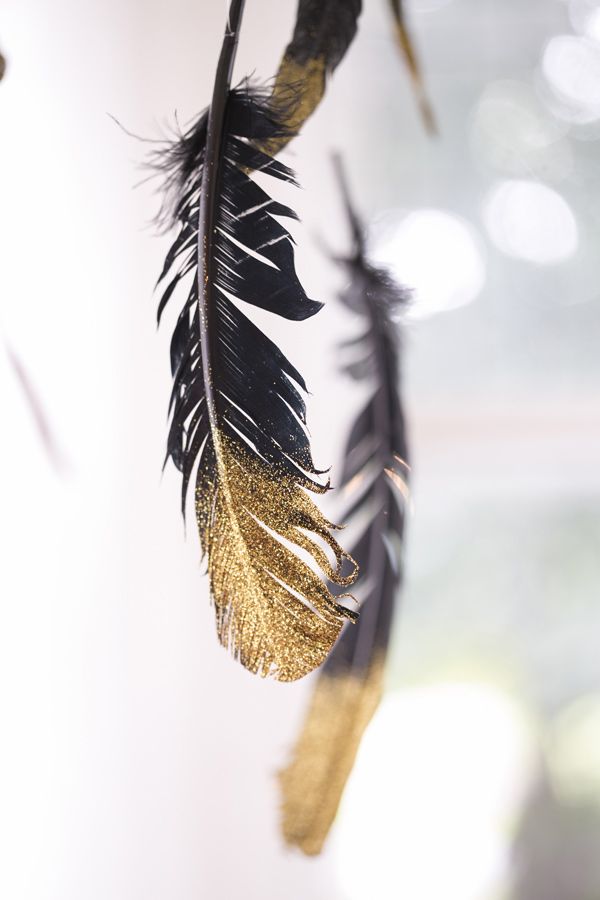 black and gold feathers will be a fun decor idea for such a wedding