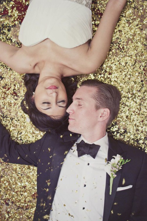 a groom wearing a black tux and a gold sequin backdrop for the wedding portraits