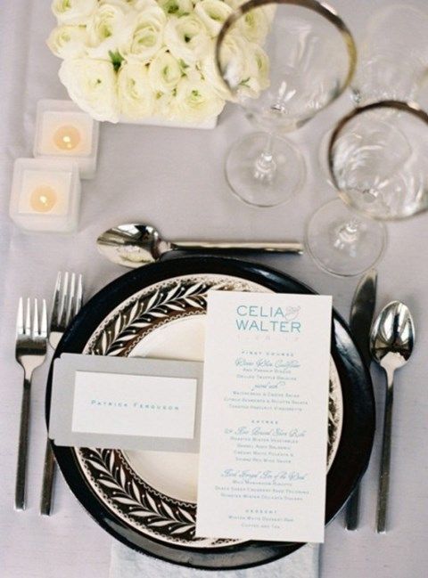a chic modern wedding tablescape with chargers and plates, white candles and blooms and some touches of grey