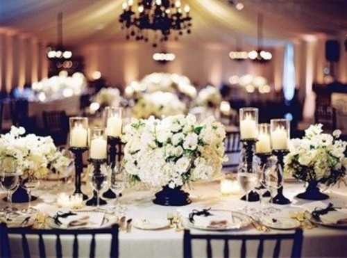 a cozy neutral tablescape with floral centerpieces and candles, touches of black - candleholders and vases