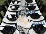 a DIY black and white tablescape with curved plates, glasses, black and white plates,