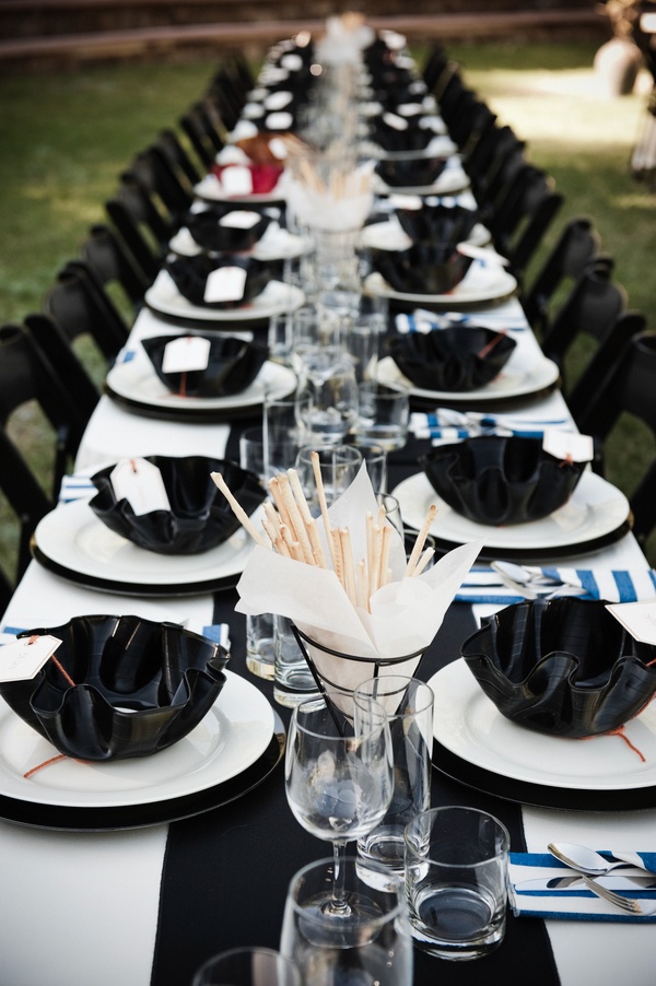 A DIY black and white tablescape with curved plates, glasses, black and white plates,