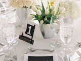a neutral tablescape with black touches – a black table number and a black menu for more drama