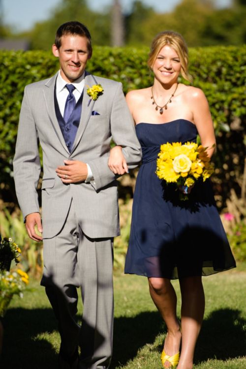 a navy strapless bridesmaid dress, a grey suit with a navy tie and yellow blooms