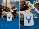 a navy tablecloth, a gold glitter deer and pinecones for a winter wedding