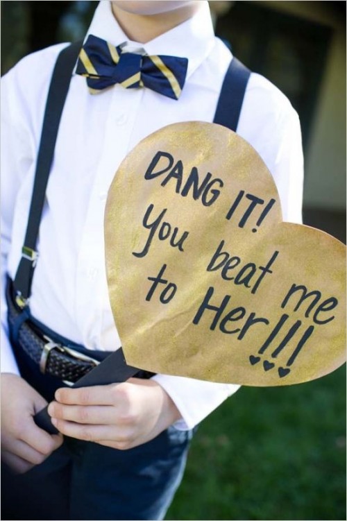 a ring bearer dressed in navy and white and with a gold and navy heart