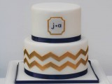 a chic white, navy and gold wedding cake with a timeless chevron pattern