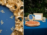 a navy and gold dessert table styled with a gold frame and a candle holder