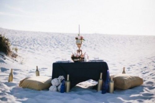 a navy and gold wedding picnic setting with a low table and pillows