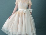 a neutral tea length wedding dress with gold lace, a high neckline, short sleeves and gold lace vintage shoes