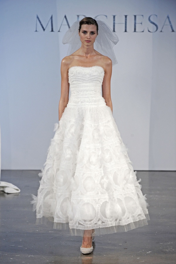 A statement strapless A line wedding dress with a tiered bodice and a printed skirt with appliques plus a veil and embellished shoes