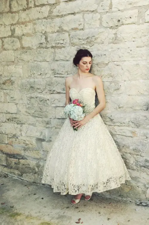 a strapless a-line wedding dress with a pleated bodice and a lace skirt, vintage shoes and pearl earrings to finish off the look