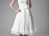 a plain A-line tea length wedding dress with a high neckline, cap sleeves and a pleated skirt plus vintage shoes and a strand of pearls for a vintage look