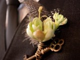 a vintage wedidng boutonniere of feathers, a vintage key and some blooms is a lovely accessory for a vintage-inspired groom’s look
