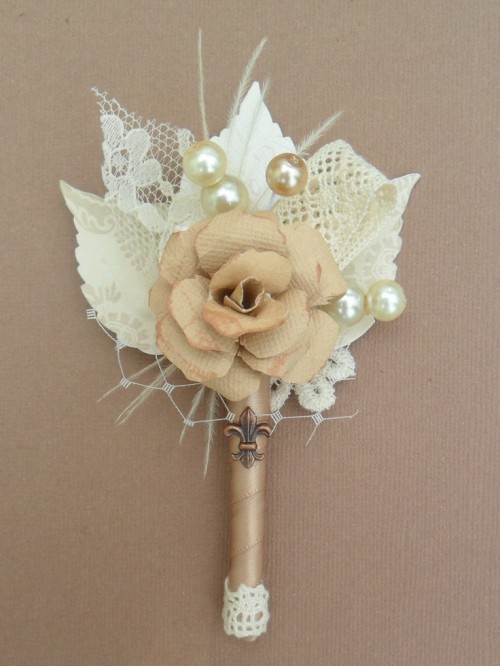 a neutral vintage wedding boutonniere of lace, fabric leaves and a fabric bloom, pearls and a twine wrap is a chic and refined accessory for a wedding