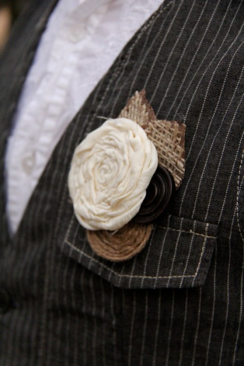 a simple vintage boutonniere composed of burlap leaves and a white fabric flower is a stylish idea for a vintage and not only groom's look